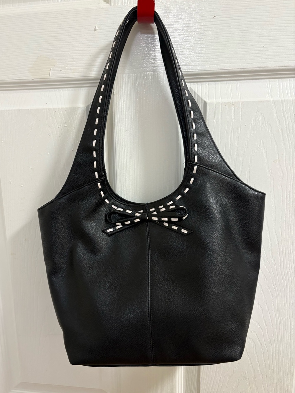 black hobo-style shoulder bag , measures 9 by 14 by 4 inches